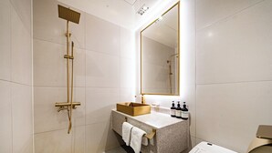 A modern bathroom with a freestanding shower, a large mirror, a granite countertop, and a toilet. - Instar Hotel (Suwon)