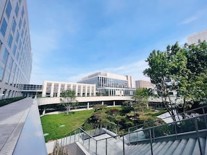 A modern building with a glass facade, a central courtyard with greenery, and a staircase leading to an upper level. - Vision Plaza Shahe Intl. Cultural Center (Changping)