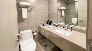 Un baño moderno con inodoro, lavamanos y espejo.