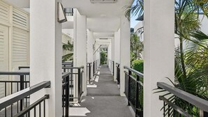 A corridor with white walls, black railings, and a concrete floor. - Beachside Family Retreat - Paradiso 111 (Tweed)