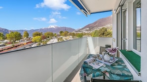 A balcony with a table set for tea, a view of mountains, and a clear sky. - Il Tenero Appartamento With Balcony and Parking (Tenero-Contra)