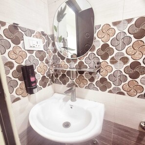 Un bagno con un lavandino bianco, uno specchio e una parete decorata con un motivo a monete.