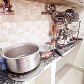 Una cucina con una pentola in acciaio inossidabile, una padella e un portauova con utensili.
