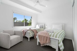 Ein Schlafzimmer mit Bett, Sofa, Schreibtisch und Fenster.