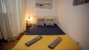 Een hotelkamer met een bed, een schilderij aan de muur en een lamp op een nachtkastje.