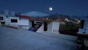 A rooftop with a sign for 'Malabar Resort & Spa' and a motorcycle parked to the side. - Malabar Cottage - Panoramic Mountain View (Kodaikanal)