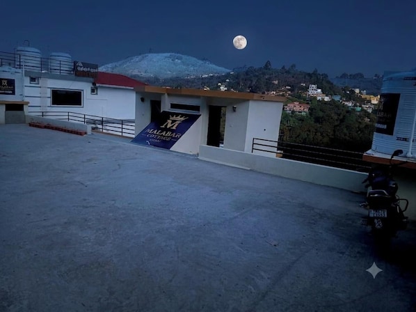 A rooftop with a sign for 'Malabar Resort & Spa' and a motorcycle parked to the side. - Malabar Cottage - Panoramic Mountain View (Kodaikanal)