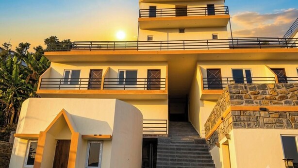A multi-story building with a central staircase leading to an upper level. - Malabar Cottage - Panoramic Mountain View (Kodaikanal)
