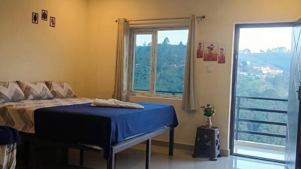 A bedroom with a bed, a window, and a balcony. - Malabar Cottage - Panoramic Mountain View (Kodaikanal)