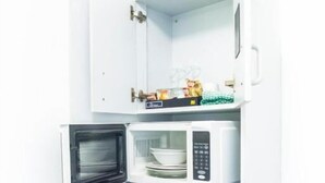 Une cuisine compacte équipée d’un four à micro-ondes, d’une bouilloire et d’un petit réfrigérateur.
