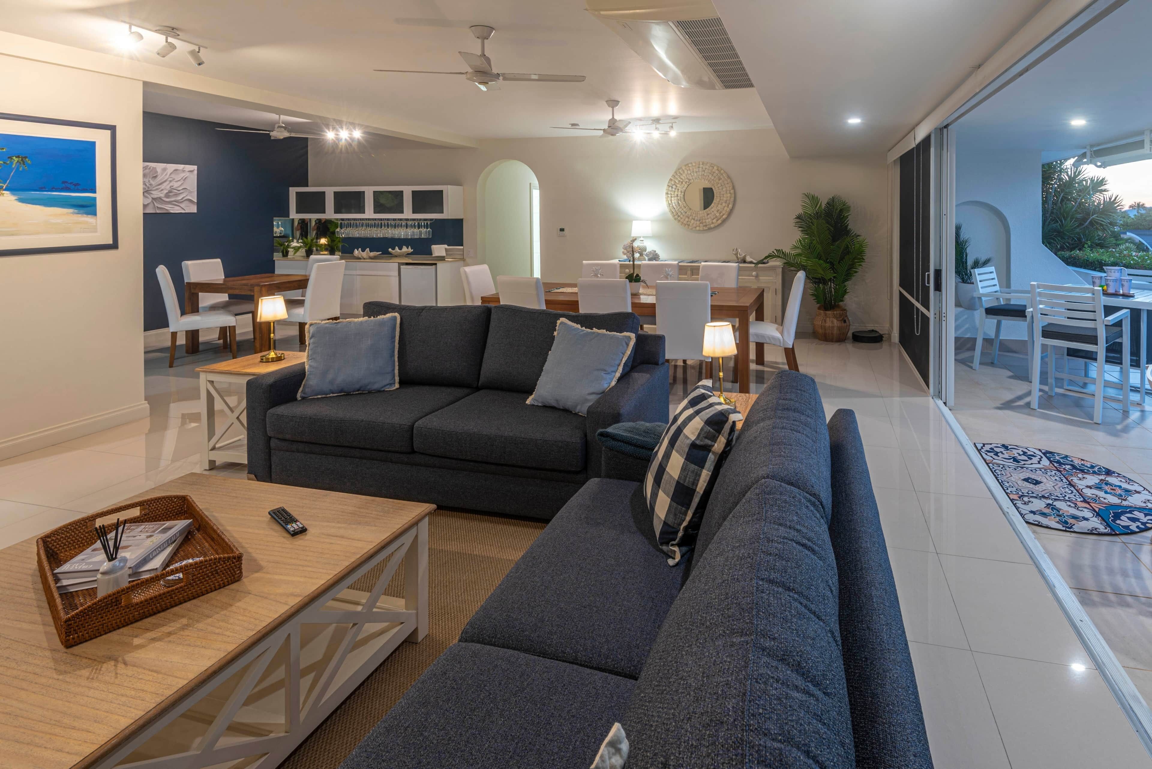 A modern living room with a sofa, coffee table, and dining area.