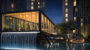 Ein modernes Hotel mit Glasfassade, einem Wasserfall und einem Pool.