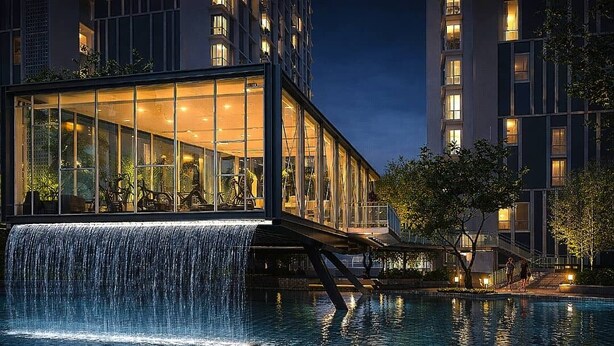 Um hotel moderno com fachada de vidro, cascata e piscina.