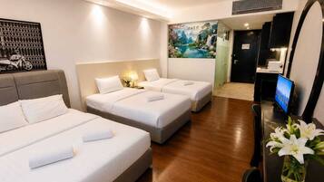 A hotel room with three beds, a television, a mirror, and a painting on the wall.