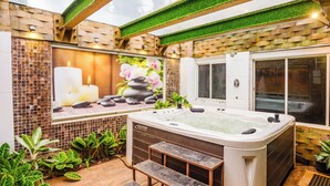 A spa area with a hot tub, steps, and a mosaic wall. - Moonstone Meadows Suite By Alaya Stays (Mawal)