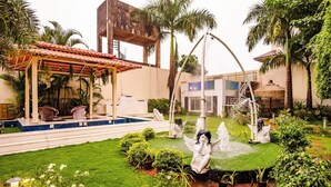 A garden with a gazebo, a fountain, and statues. - Moonstone Meadows Suite By Alaya Stays (Mawal)