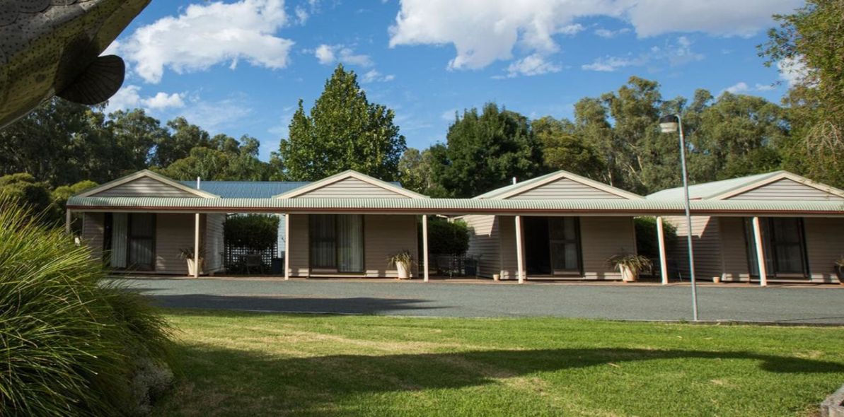 A row of three single-story buildings with flat roofs, each with a covered porch.