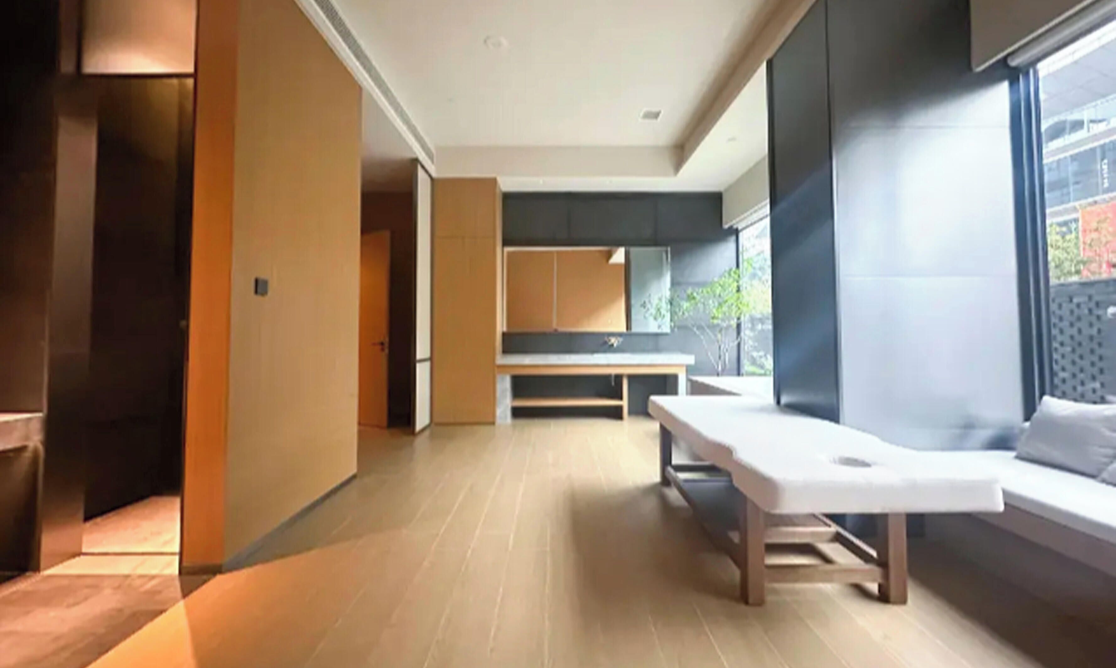 Une chambre moderne avec un plancher en bois, un banc et un lit donnant sur une fenêtre.