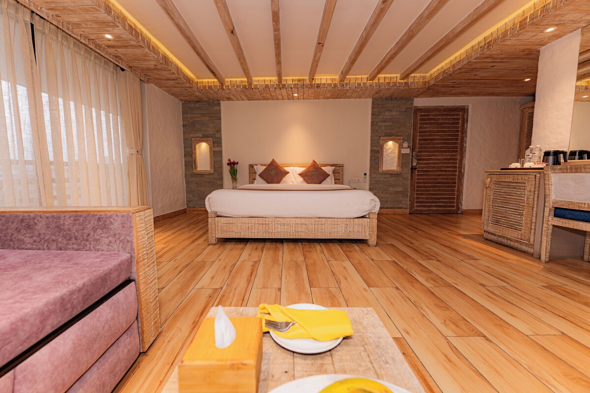 A bedroom with a bed, bedside table, and a wooden floor.