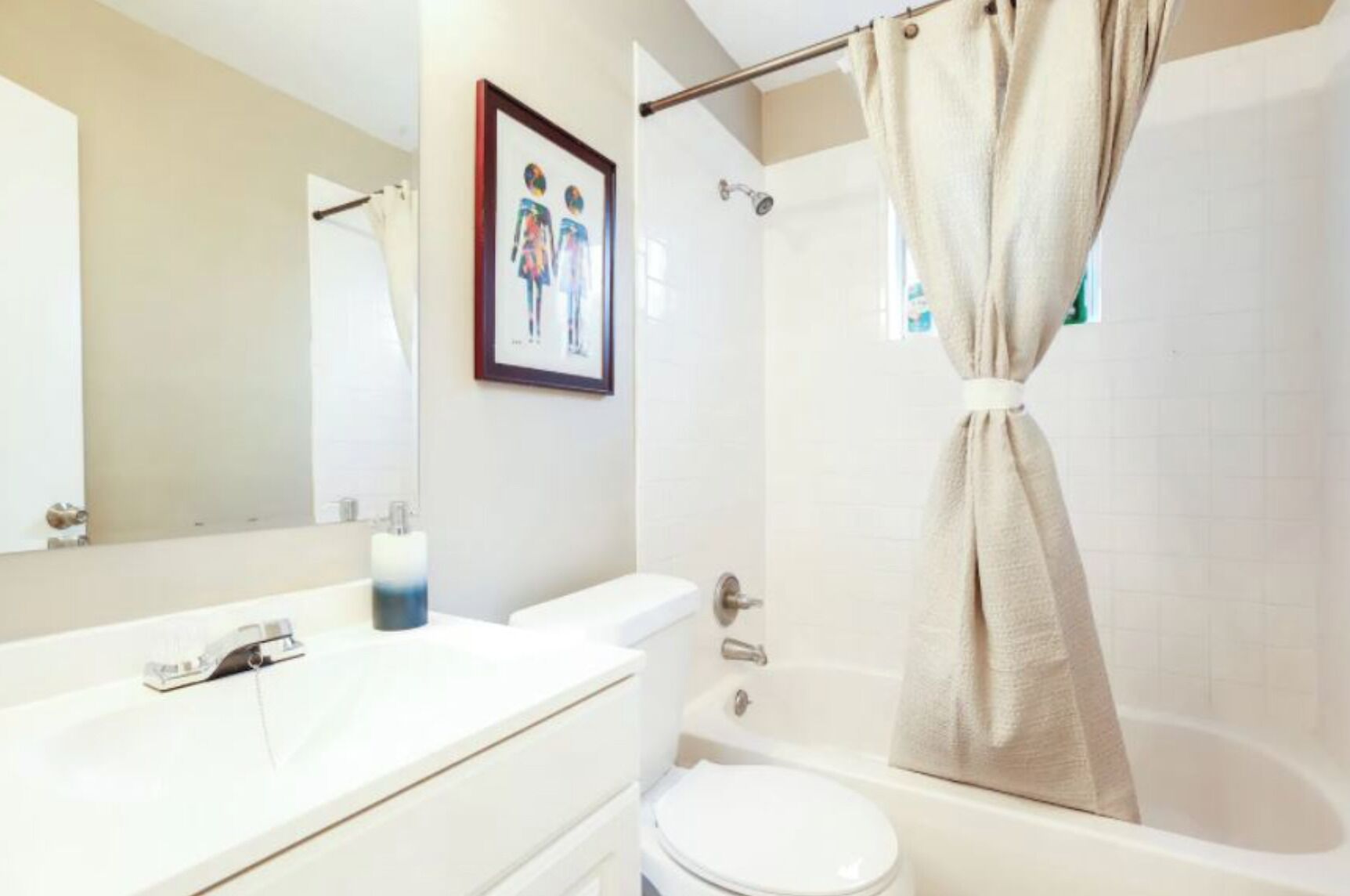 A bathroom with a bathtub, toilet, and sink.