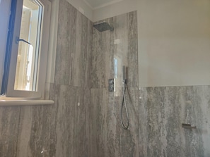 A shower with a handheld showerhead and a wall-mounted control panel. - Holiday Home Casa Simone in Lido (Camaiore)