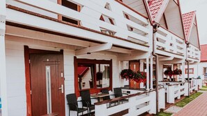 A row of white buildings with balconies, wooden railings, and red-tiled roofs. - Single-story Holiday Homes Close to the Beach (Ustronie Morskie)