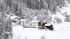A snow-covered mountain resort with multiple buildings, including a large lodge and smaller cabins, surrounded by dense forest. - Apartment in Ischgl Near Ski Lift (Ischgl)