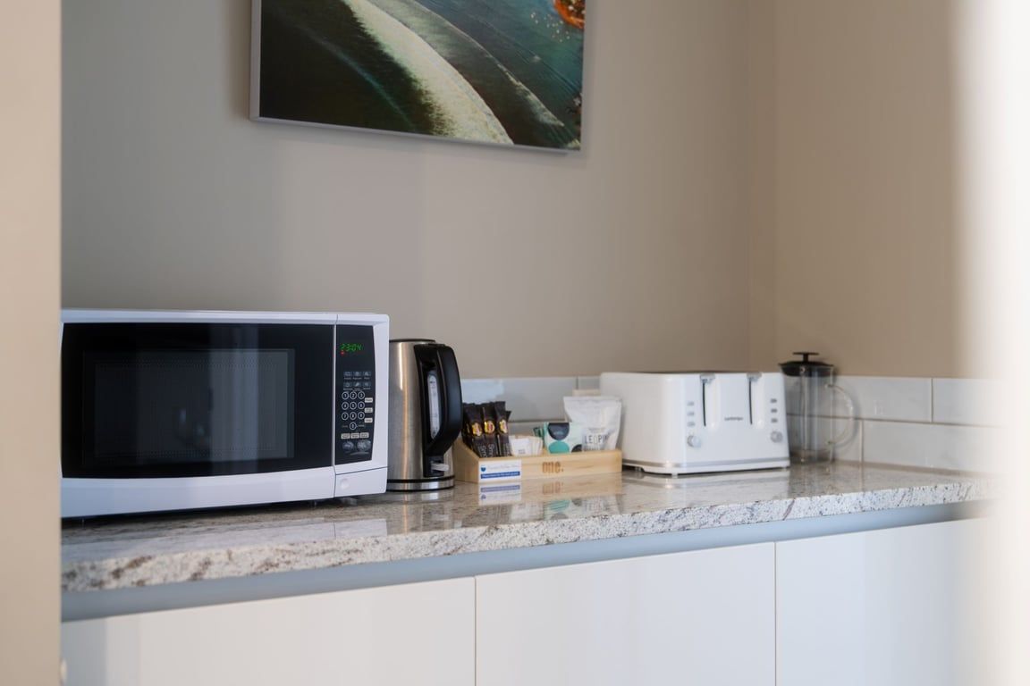 A kitchen with a microwave, coffee maker, and toaster on the counter.