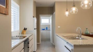 A modern kitchen with a central island, a built-in oven, and a sink.