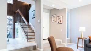 A modern living room with a staircase, a sofa, and a lamp. - 3BR The Montrose Collective C! Steps to Food & Fun! (Houston)