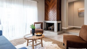 A modern living room with a fireplace, a sofa, a chair, and a coffee table. - 3BR The Montrose Collective C! Steps to Food & Fun! (Houston)