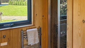 A bathroom with a window, towel rack, and a shower area. - The Rounton - UKC9284 (Brompton)