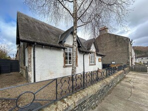 A traditional building with a stone facade, a pitched roof, and a metal fence. - 4 bedroom accommodation in Peebles (Peebles)