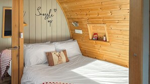A cozy bedroom with a wooden headboard, a bed with white bedding, a polka dot blanket, a pillow with a bunny design, and a wall with a motivational quote. - The Welbury - UKC9285 (Brompton)