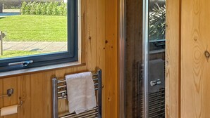 Ein Badezimmer mit Fenster, Handtuchhalter und Duschbereich.
