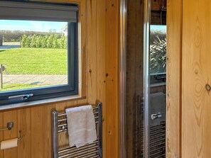 Ein Badezimmer mit Fenster, Handtuchhalter und Duschbereich.