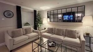 A living room with two sofas, a coffee table, a TV, and a plant. - 2 bedroom accommodation in Newcastle Upon Tyne (Newcastle Upon Tyne)