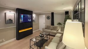 A modern living room with a flat-screen TV, a sofa, a coffee table, and a lamp. - 2 bedroom accommodation in Newcastle Upon Tyne (Newcastle Upon Tyne)