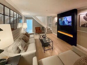A modern living room with a sofa, coffee table, and a television mounted on the wall. - 2 bedroom accommodation in Newcastle Upon Tyne (Newcastle Upon Tyne)