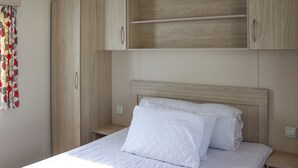 Une chambre à coucher avec un lit, une armoire en bois et une étagère au-dessus du lit.