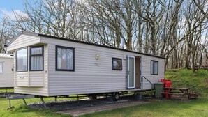 Ein Wohnmobil mit Schiebetür, Fenstern und einem kleinen Anbau.