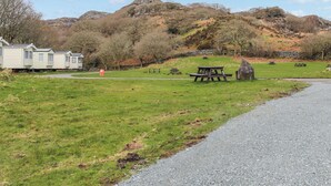 Ein Campingplatz mit Picknicktischen, einem Kiesweg und einer Reihe von Mobilheimen.