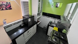 A compact kitchen with a gas stove, a sink, and a refrigerator.