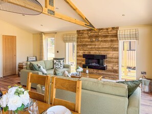 Ein geräumiges Wohnzimmer mit Kamin, Holzbalken und einer Couch.