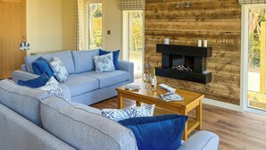 Una sala de estar moderna con un sofá gris, una mesa de centro de madera y una chimenea.