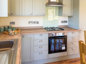 A kitchen with a built-in oven, a gas stove, and a stainless steel range hood.