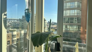 Ikkunasta avautuu näkymä kaupunkimaisemaan, johon kuuluu rakennuksia ja silta.