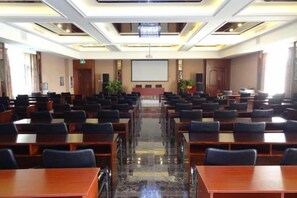 A conference room with rows of tables and chairs, a projector screen, and a large window. - Longyuan Holiday Hot Spring Hotel (Anshan)