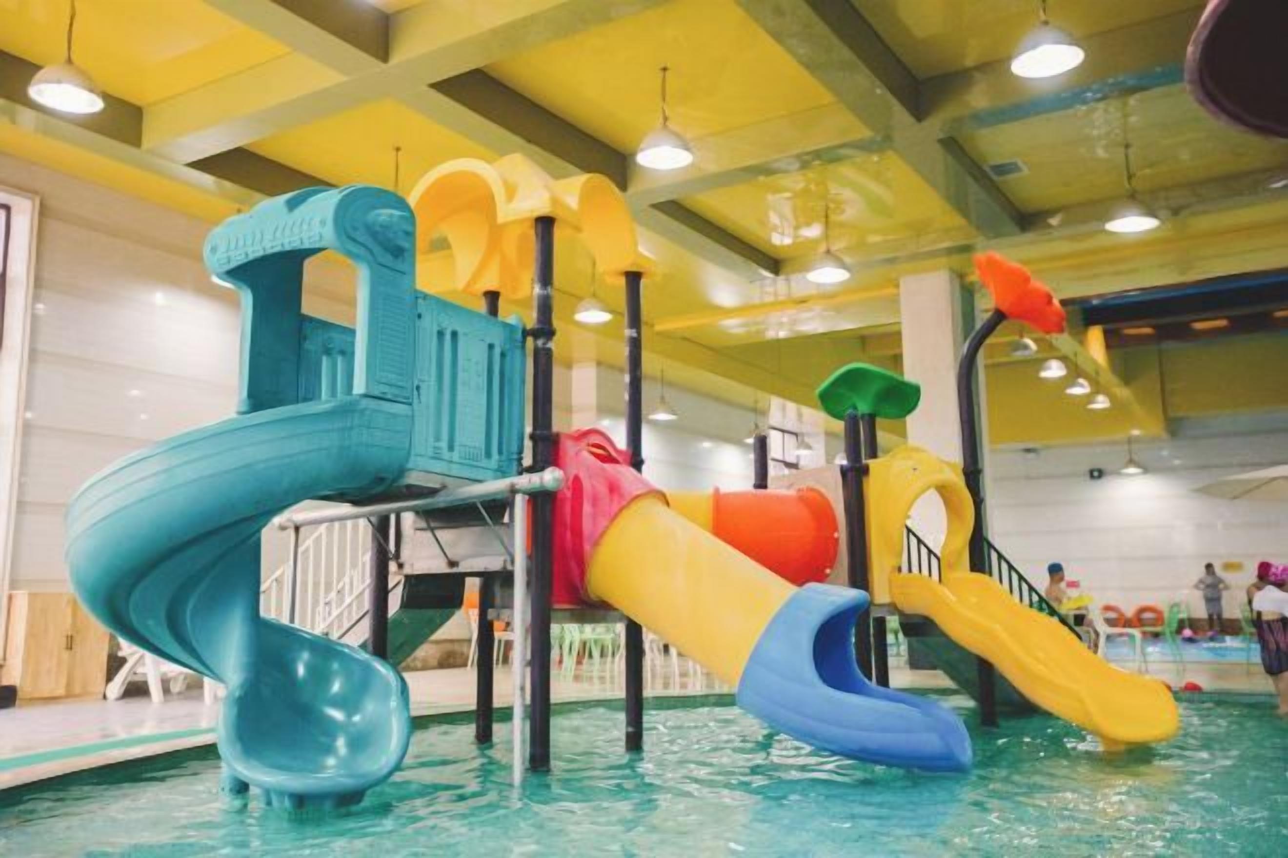 An indoor water park with multiple slides and play structures.