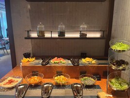 A buffet setup with various food items and condiments.